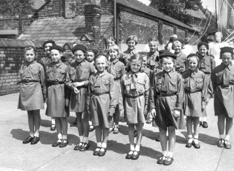 Brownies assemble in school yard, c1950. Brownies assemble in school yard, c1950.