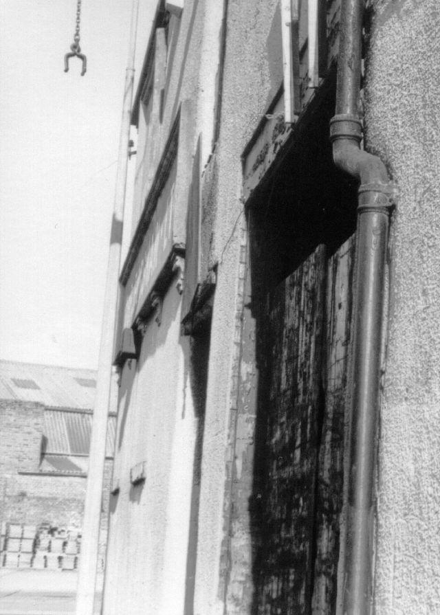 The view outside with the hook they used to lift the bales of woolens to the top floor, c1984. The view outside with the hook they used to lift the bales of woolens to the top floor, c1984.