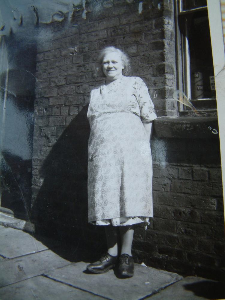 Agnes McGuinn in front of her shop, number 11