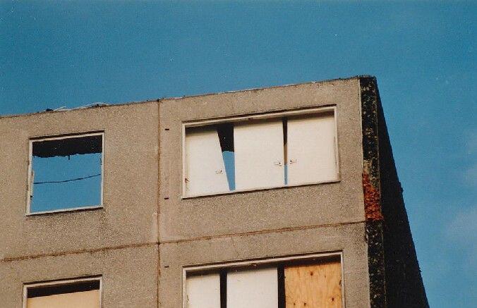 Telephoto lens shot of top floor of block.