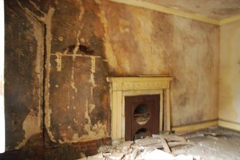 Old fireplace and cracks in wall